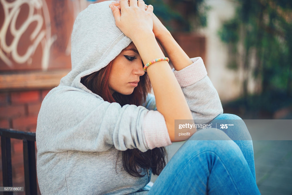 Lonely teenager sitting outdoors